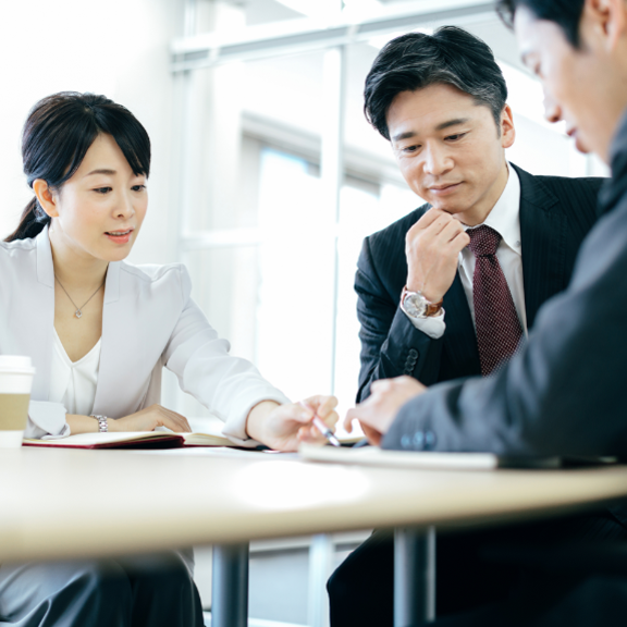 Japanese business people sitting on a table and discussing